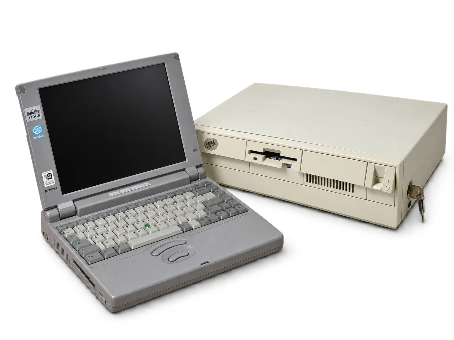 Szary laptop Toshiba Satellite i beżowa obudowa IBM z kluczykiem